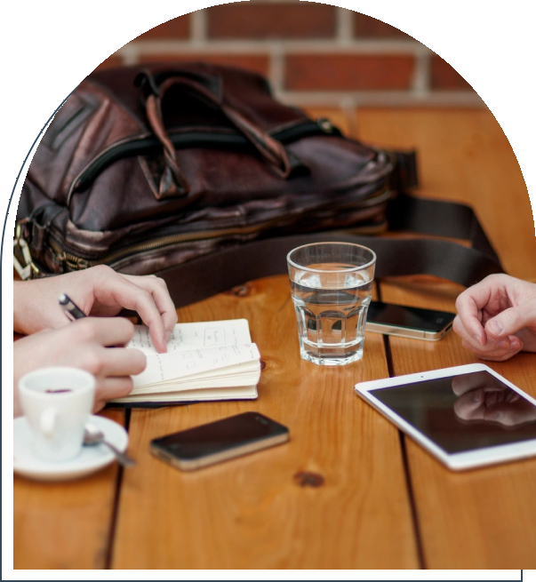 A group of people sitting at a table with drinks and cell phones.